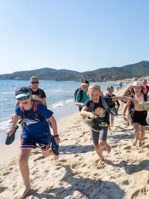 Mehrere Kinder laufen am Strand entlang